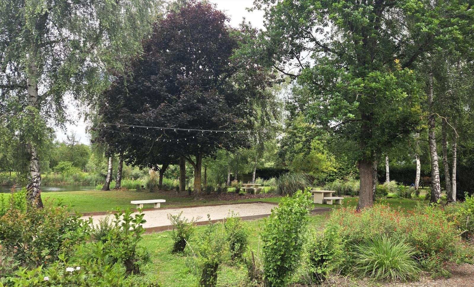 Le parc et le terrain de pétanque de jour, l'étang en fond — Les Étangs de l'Abbaye